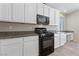 Modern kitchen featuring white cabinets, black appliances, and a gas range at 6403 Dundock Ave, Las Vegas, NV 89122