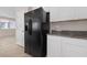 Bright kitchen features a large, stainless steel refrigerator and white cabinets with granite countertops at 6403 Dundock Ave, Las Vegas, NV 89122