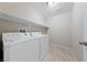 Well-equipped laundry room featuring new washer and dryer and tiled floors with utility shelving at 6403 Dundock Ave, Las Vegas, NV 89122