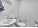 Bright powder room featuring a pedestal sink, round mirror, and essential fixtures at 6952 Crimson Shadow St, North Las Vegas, NV 89086