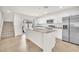 Open kitchen boasts white cabinets, stainless appliances, center island and backyard access at 6952 Crimson Shadow St, North Las Vegas, NV 89086