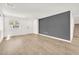 Open-concept living space with light flooring, a gray accent wall, and natural light at 6952 Crimson Shadow St, North Las Vegas, NV 89086