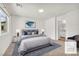 This staged bedroom has a large window, a calming color scheme, and an en-suite bathroom at 6952 Crimson Shadow St, North Las Vegas, NV 89086