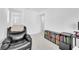 Relaxing sitting area with a recliner and bookshelf, illuminated by natural light at 6952 Crimson Shadow St, North Las Vegas, NV 89086