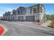 Townhome exteriors showing private garages and colorful shutters and doors and manicured landscaping on a sunny day at 7204 N Decatur Blvd, North Las Vegas, NV 89131