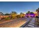 Spacious backyard featuring mature trees, lush landscaping, stone pathways, and ambient lighting at 7311 Velvet Sky St, Las Vegas, NV 89131
