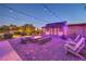 Cozy backyard featuring a brick patio, fire pit, string lights, and comfortable seating, ideal for gatherings at 7311 Velvet Sky St, Las Vegas, NV 89131