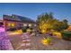 The backyard has beautiful desert landscaping, a stone pathway, and mature trees surrounding the property at 7311 Velvet Sky St, Las Vegas, NV 89131
