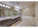 Bright bathroom features double sinks, soaking tub, and ample vanity space at 7311 Velvet Sky St, Las Vegas, NV 89131