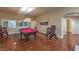 Cozy billiard room with hardwood floors, pool table, adjacent bathroom, and window with natural light at 7311 Velvet Sky St, Las Vegas, NV 89131