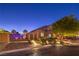 Charming home featuring brick accents, landscaped front yard, and iron gate, illuminated by step lighting at 7311 Velvet Sky St, Las Vegas, NV 89131
