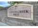 Community entrance sign reading Canyon Creek West on a stone wall under a blue sky at 8301 Shad Bush Ave, Las Vegas, NV 89149