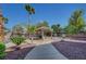 Lush backyard featuring a charming tiki hut, palm trees, and desert landscaping on a sunny day at 8370 Unicorn St, Las Vegas, NV 89131
