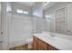 Bathroom featuring a shower-tub, wood vanity, a framed mirror, and a small window at 8370 Unicorn St, Las Vegas, NV 89131