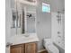 Bright bathroom featuring a wooden vanity, tile flooring, and a combined tub and shower at 8370 Unicorn St, Las Vegas, NV 89131
