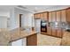 Open kitchen features granite countertops, stainless steel appliances, and warm wood cabinets at 8370 Unicorn St, Las Vegas, NV 89131