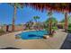 Backyard view showcasing swimming pool, palm trees and tiki hut, surrounded by lush landscaping and gravel at 8370 Unicorn St, Las Vegas, NV 89131