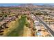 Panoramic aerial view of a residential community nestled beside a lush golf course with mountain views at 9425 Villa Ridge Dr, Las Vegas, NV 89134