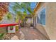 Backyard features a pergola, a small palm tree, and a patio with chairs at 9557 Cabot Falls Ave, Las Vegas, NV 89149