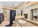 Bathroom featuring a shower and tub combo with granite countertops, a mirror and a blue shower curtain at 9557 Cabot Falls Ave, Las Vegas, NV 89149