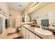 Bright bathroom featuring double sinks, granite countertops, and neutral-colored walls at 9557 Cabot Falls Ave, Las Vegas, NV 89149