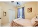 This is a bedroom featuring a ceiling fan, closet and a window with curtains for natural light at 9557 Cabot Falls Ave, Las Vegas, NV 89149