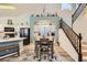 Well lit dining area with a modern chandelier, stairs, and beach themed decor at 9557 Cabot Falls Ave, Las Vegas, NV 89149