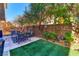 Outdoor patio area with artificial grass and mature landscaping at 9692 Waukegan Ave, Las Vegas, NV 89148