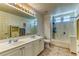 Bright bathroom with double sink vanity, tiled floors, and shower with tub at 9692 Waukegan Ave, Las Vegas, NV 89148