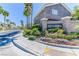 Beautiful community entrance with lush landscaping, flowers, and palm trees at 9692 Waukegan Ave, Las Vegas, NV 89148
