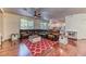 Bright living room with hardwood floors, comfortable seating, and a red patterned rug at 9692 Waukegan Ave, Las Vegas, NV 89148