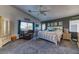Spacious main bedroom featuring a ceiling fan, neutral color palette, large bed, and window with natural light at 9692 Waukegan Ave, Las Vegas, NV 89148
