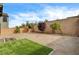 A spacious backyard area with gravel, artificial turf, trees, and a block wall fence for privacy at 9993 Birch Knoll Ave, Las Vegas, NV 89166