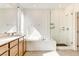 Modern bathroom featuring a soaking tub, glass shower, and vanity with double sinks at 9993 Birch Knoll Ave, Las Vegas, NV 89166