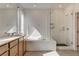 Well-lit bathroom with dual sinks, separate tub, and a glass shower at 9993 Birch Knoll Ave, Las Vegas, NV 89166