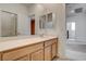 Bright secondary bathroom with a large mirror, quartz countertops, and a wooden vanity at 9993 Birch Knoll Ave, Las Vegas, NV 89166