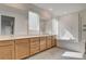 Bright bathroom featuring dual sinks, a soaking tub, and a glass-enclosed shower at 9993 Birch Knoll Ave, Las Vegas, NV 89166