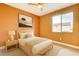 Bedroom with orange walls, a bed, a window, and a painting hung on the wall at 9993 Birch Knoll Ave, Las Vegas, NV 89166