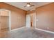 Neutral-toned bedroom featuring carpet, a ceiling fan, and access to a closet and bathroom at 9993 Birch Knoll Ave, Las Vegas, NV 89166