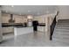 Modern kitchen with stainless appliances, breakfast bar, and adjacent stairway to upper level at 9993 Birch Knoll Ave, Las Vegas, NV 89166