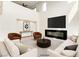 Staged living room with a fireplace, large screen tv, modern sofas and chairs, and high ceilings at 9993 Birch Knoll Ave, Las Vegas, NV 89166