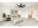 A staged bedroom with a ceiling fan and art pieces on the wall at 9993 Birch Knoll Ave, Las Vegas, NV 89166