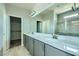Bathroom with double sinks, quartz countertop, large mirror, and a glass-enclosed shower at 10271 Bark Pine Ct, Las Vegas, NV 89166