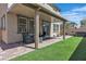 Inviting covered back patio with brick pavers, lawn, hot tub and seating, ideal for outdoor relaxation and entertaining at 10367 Andele Ave, Las Vegas, NV 89166