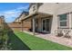 Well-maintained backyard featuring a covered patio, turf, and partial privacy wall at 10367 Andele Ave, Las Vegas, NV 89166