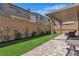 Inviting backyard with a covered patio, artificial grass, and privacy landscaping at 10367 Andele Ave, Las Vegas, NV 89166
