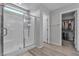 Modern bathroom featuring a glass-enclosed shower and a glimpse into a walk-in closet at 10367 Andele Ave, Las Vegas, NV 89166