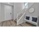 Inviting entryway with wood floors, white trim, staircase, and a comfortable bench with decorative pillows at 10367 Andele Ave, Las Vegas, NV 89166