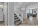 Bright entryway with staircase, wood floors, a modern light fixture, and access to the living room at 10367 Andele Ave, Las Vegas, NV 89166