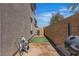 Narrow side yard with turf area and gravel, featuring air conditioning unit, grill, and yard cleaning supplies at 10367 Andele Ave, Las Vegas, NV 89166